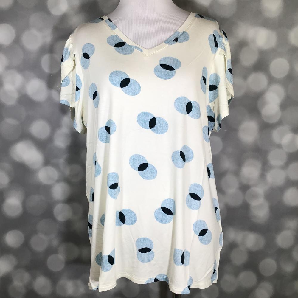 Cream LuLaRoe Remi top with blue and black circular dot print and tulip sleeves, displayed on mannequin against a blurred gray background