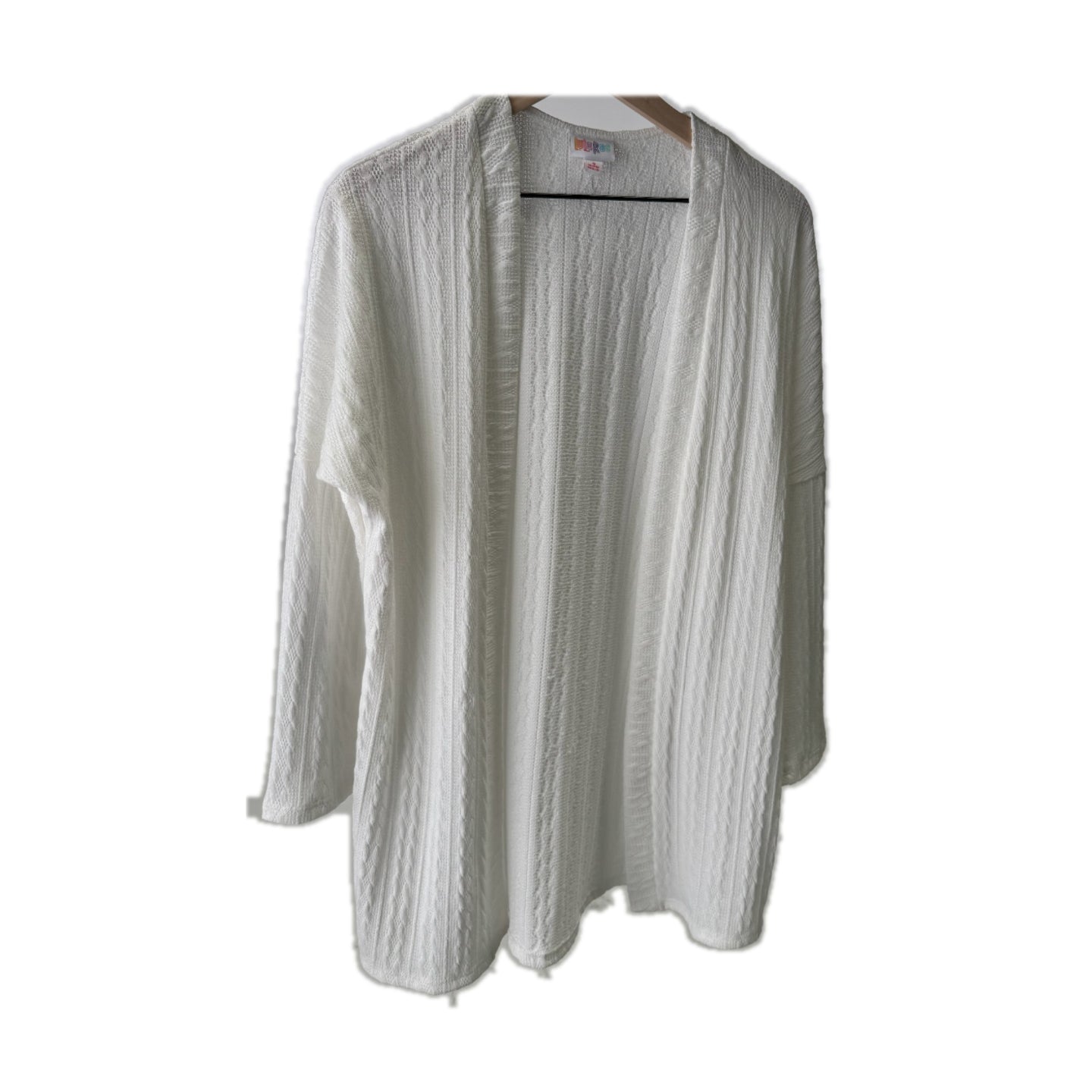 LuLaRoe Connie Lightweight Overlay in Solid White featuring a lightweight cable knit texture, open front cardigan, relaxed fit, and long sleeves layered over a white ribbed tank.