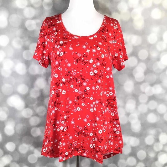 Front view of LuLaRoe Classic T displayed on mannequin in bright red fabric with pink and white ditsy floral print and flattering curved hem