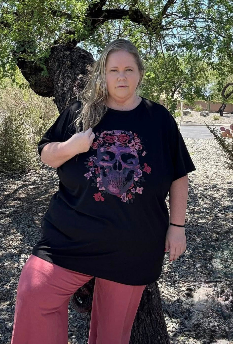 Person wearing a black t-shirt with a colorful design outdoors