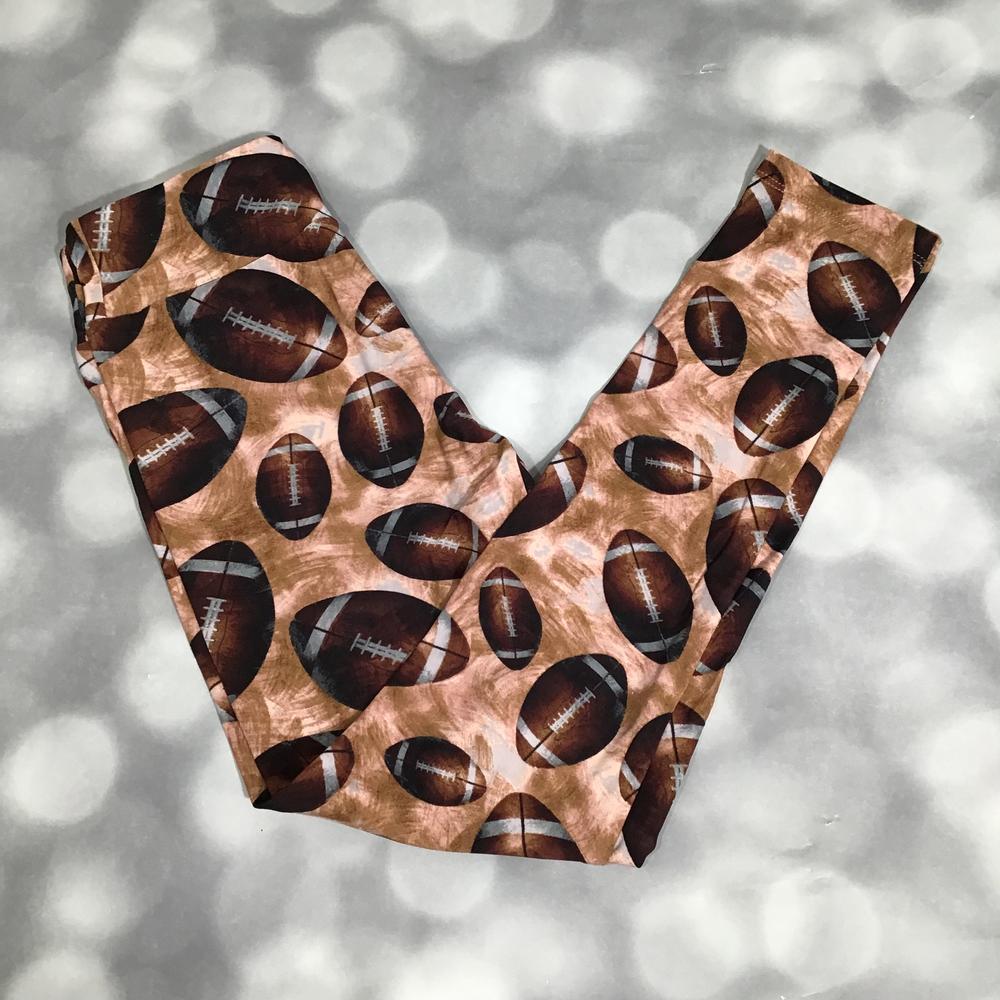 Flat lay of LuLaRoe leggings in brown background with novelty football print, yoga waistband, and ankle-length silhouette