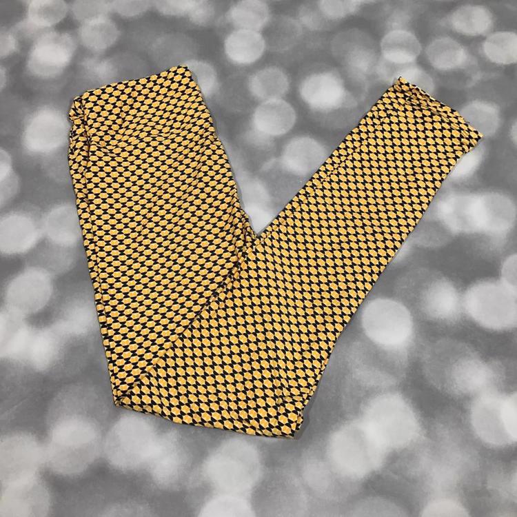 Flat lay of LuLaRoe leggings in yellow and black geometric mosaic print with yoga waistband and slim ankle-length fit