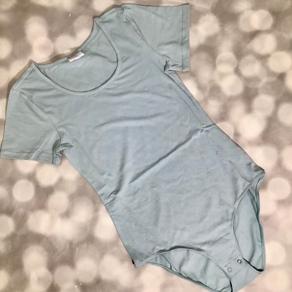 LuLaRoe Faith Bodysuit in solid light blue with short sleeves, scoop neckline, and snap closure