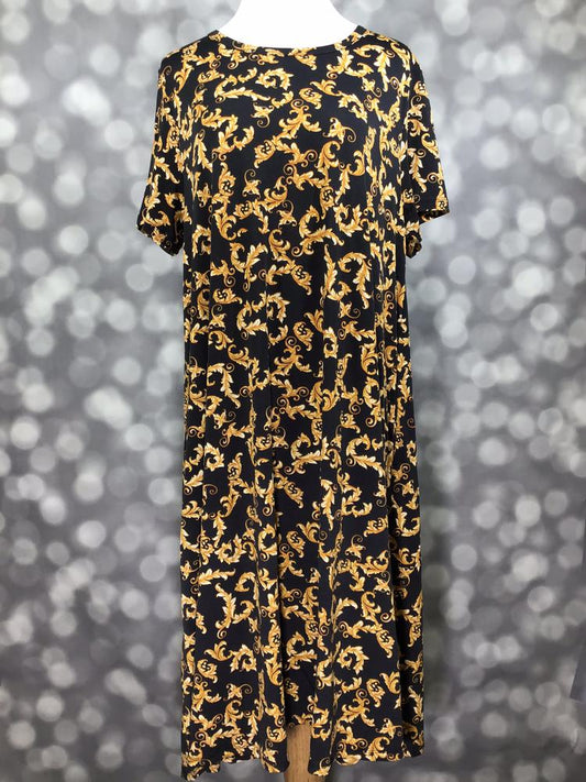 Front view of LuLaRoe Jessie dress on mannequin in black with ornate gold baroque swirl print, short sleeves, and flowy swing fit