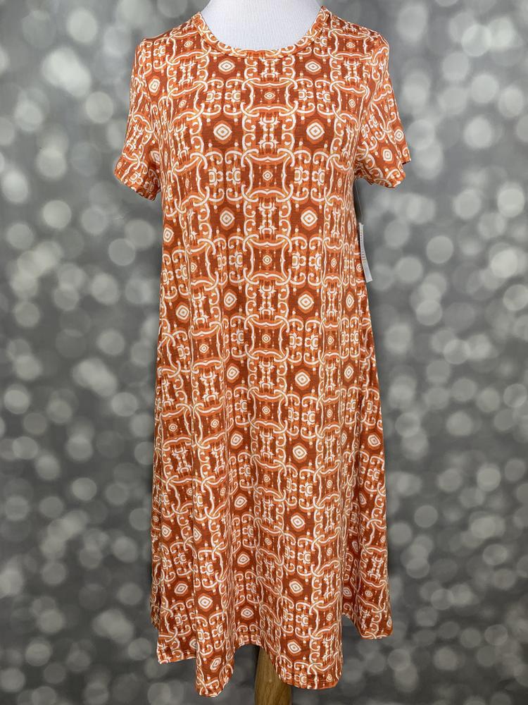 Front view of LuLaRoe Jessie dress on mannequin in terracotta orange geometric chain pattern with short sleeves, scoop neckline, and flowy swing fit