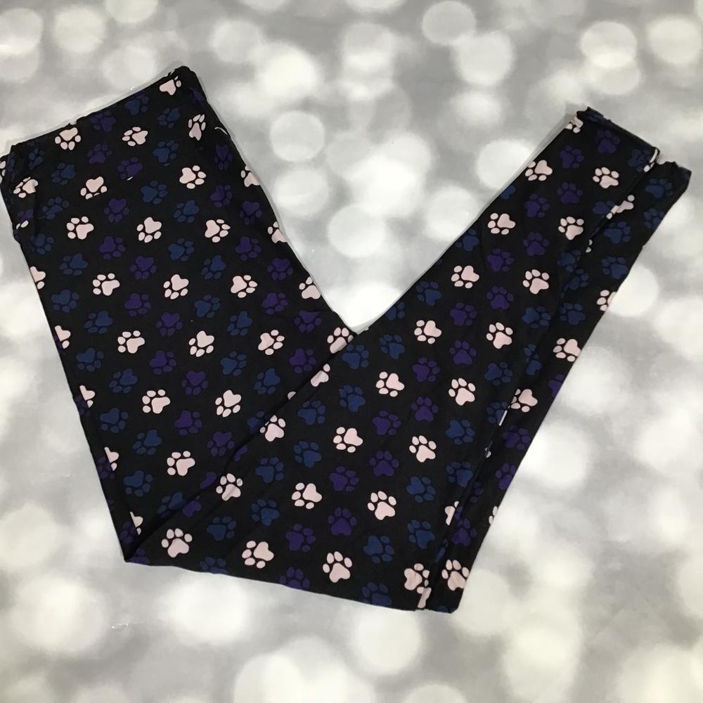 Black leggings with pink paw prints on a blurred background