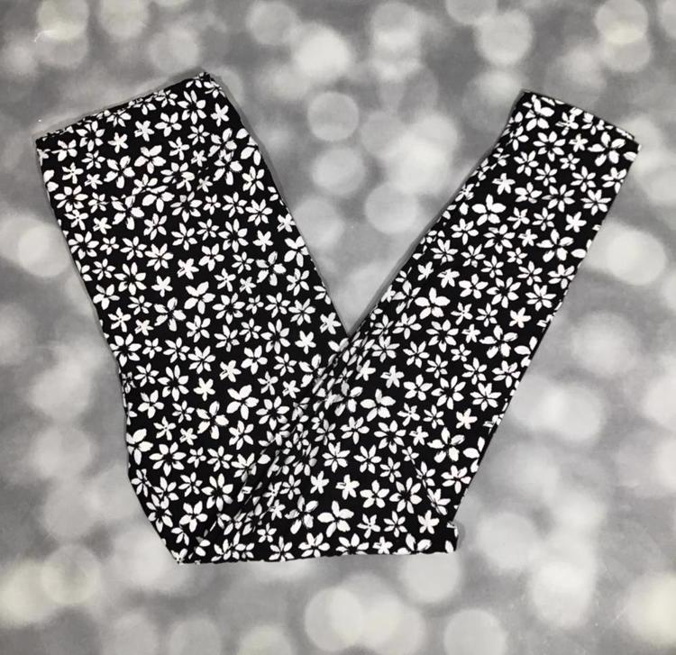 LuLaRoe leggings in black with white all-over floral print, featuring scattered flower silhouettes for a chic, versatile style.