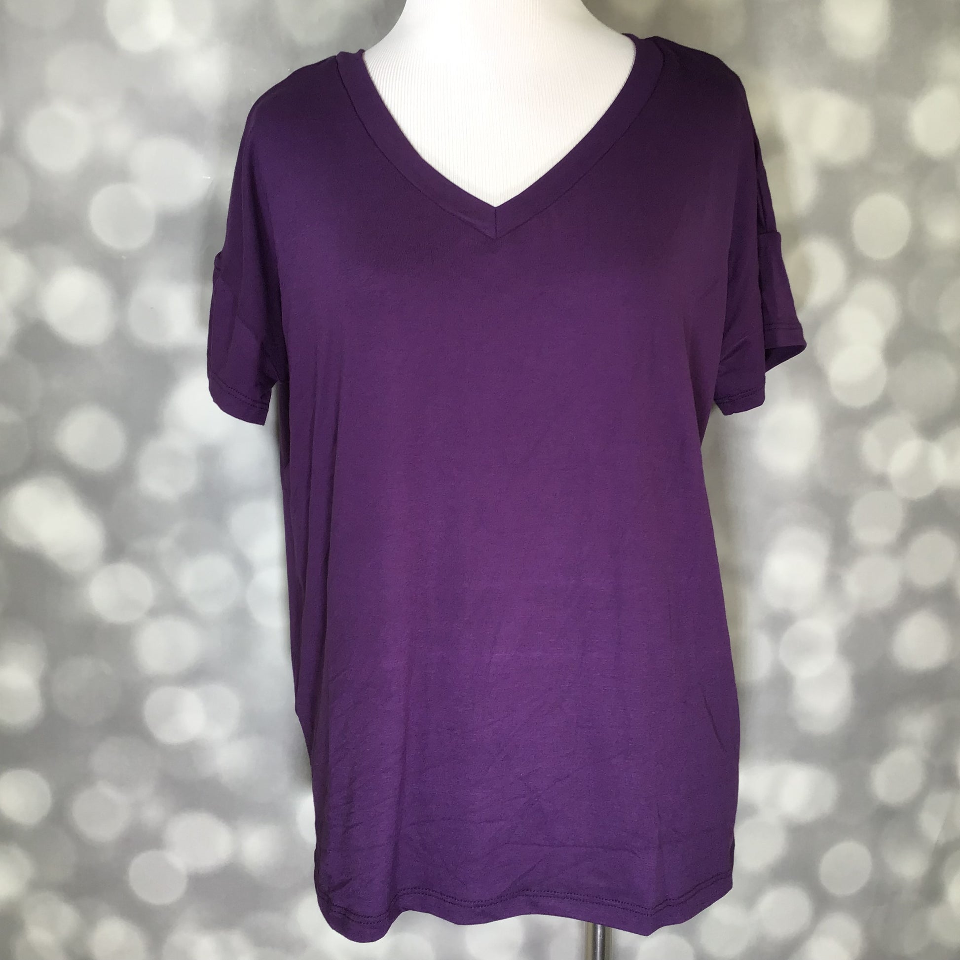 Purple v-neck top on a mannequin against a blurred background