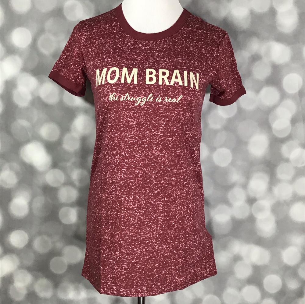 Front view of LuLaRoe Liv T on mannequin in heathered burgundy with ivory ‘Mom Brain – the struggle is real’ lettering and contrasting neckline trim against a blurred background