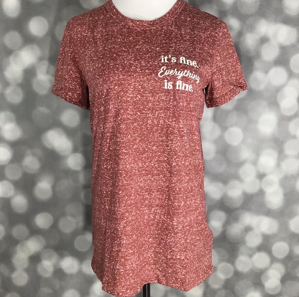 LuLaRoe Liv Tee in heathered red with white graphic text reading “it’s fine. Everything is fine" on a blurred gray background
