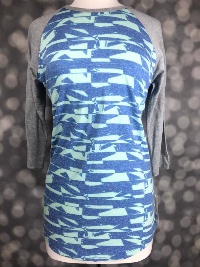 Front view of LuLaRoe Randy T displayed on mannequin, featuring aqua and blue abstract stripe print body with grey raglan 3/4 sleeves