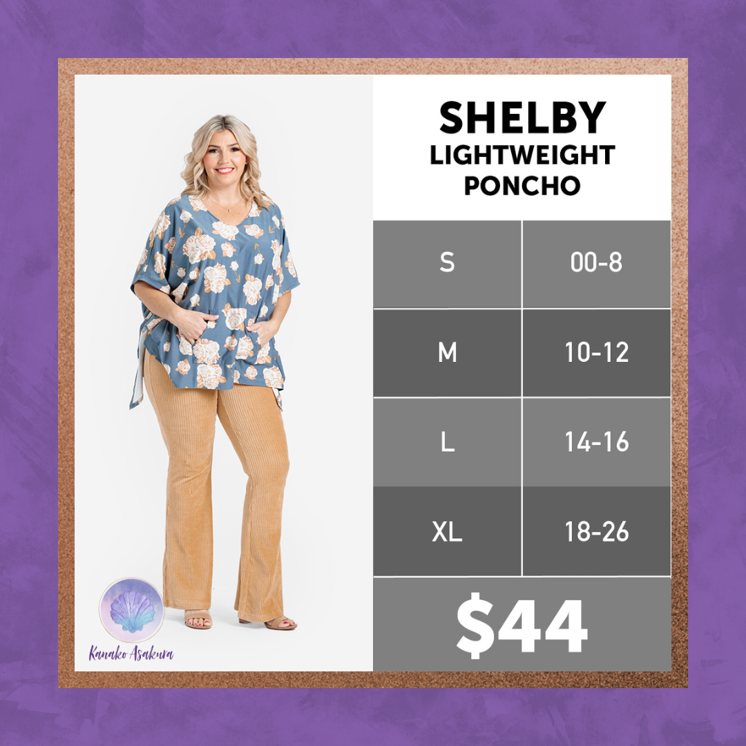 Model wearing LuLaRoe Shelby Lightweight Poncho in blue floral with kangaroo pocket, V-neck, and elbow-length armholes.