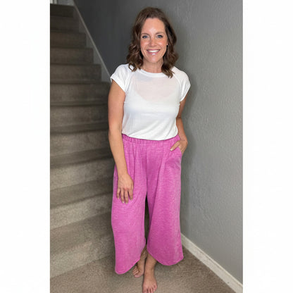 Woman wearing pink 'Justine' wide leg cropped pants by stairs indoors