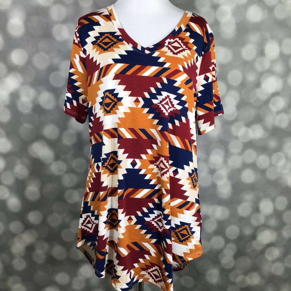 LuLaRoe Iris Tee in Canyon Sunset Aztec featuring a southwestern geometric print in canyon orange, burgundy, navy, and ivory with a rounded v-neckline, relaxed sleeves, and tunic-length silhouette.