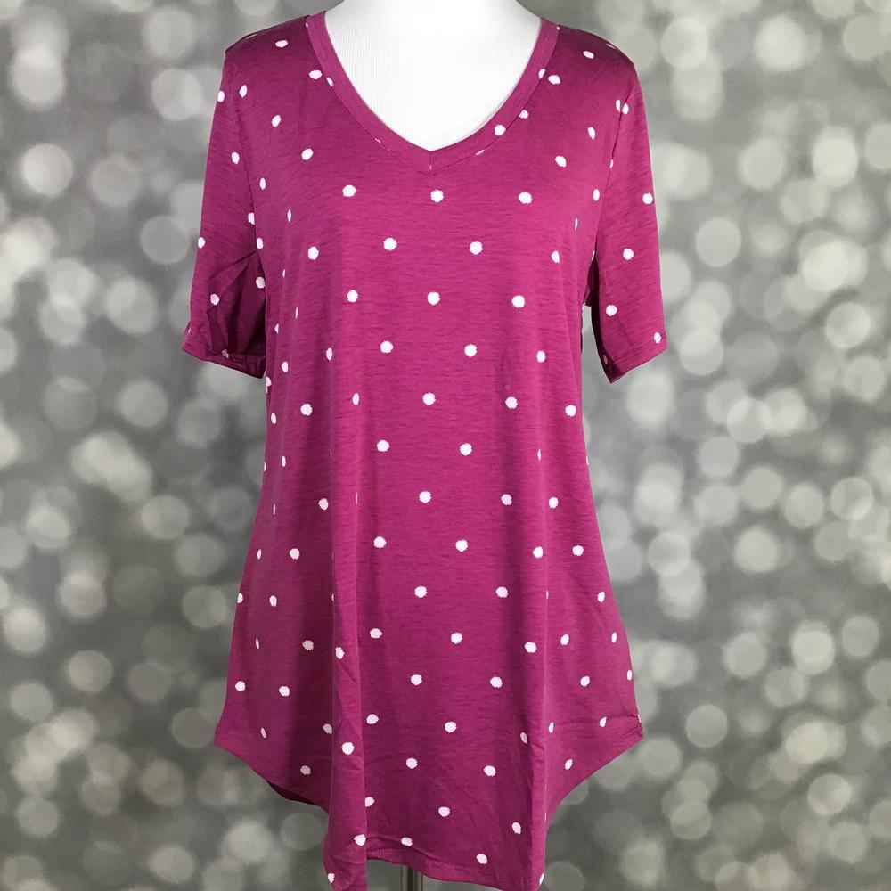 LuLaRoe Iris Tee in Berry Polka Dot featuring a rich berry pink background with classic white polka dots, rounded v-neckline, relaxed sleeves, and a tunic-length silhouette with a curved shirttail hem.