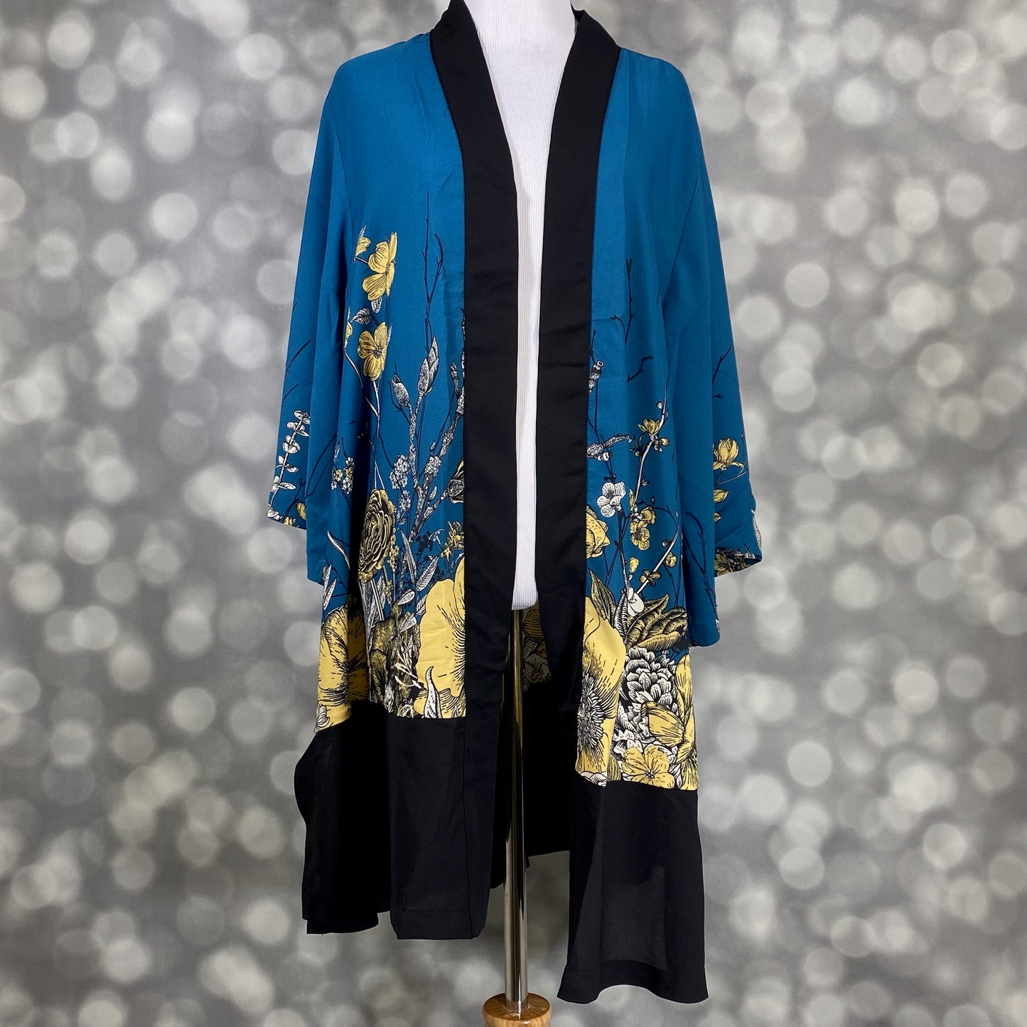 LuLaRoe Aurora bell sleeve kimono in a teal, yellow and black botanical floral print