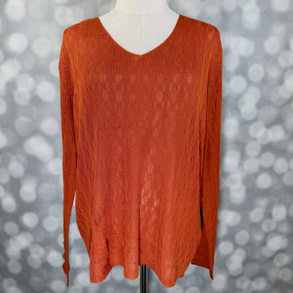 An orange long-sleeve V-neck knit top displayed on a mannequin torso against a gray bokeh background.