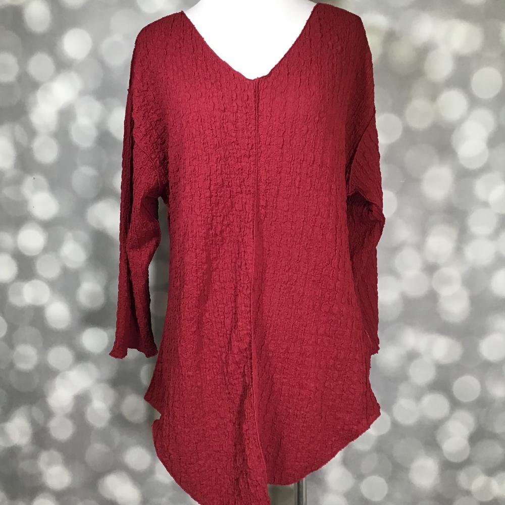 LuLaRoe Jolene V-neck tunic in solid crimson red bubble jacquard fabric displayed on mannequin.