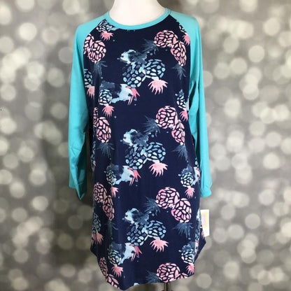 LuLaRoe Randy Tee in Island Pineapple Splash featuring watercolor pink and aqua pineapple prints on a navy background with aqua 3/4 raglan sleeves in size Large.