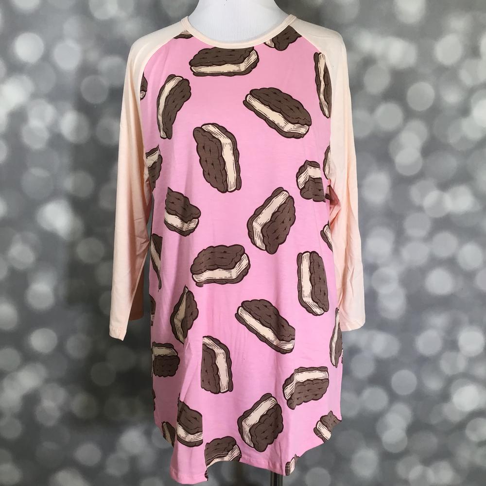 LuLaRoe Randy Tee in Sweet Ice Cream Sandwich featuring oversized chocolate ice cream sandwich illustrations on a bubblegum pink background with ivory 3/4 raglan sleeves in size Large.