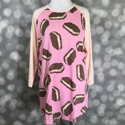 LuLaRoe Randy Tee in Sweet Ice Cream Sandwich featuring oversized chocolate ice cream sandwich illustrations on a bubblegum pink background with ivory 3/4 raglan sleeves in size Large.