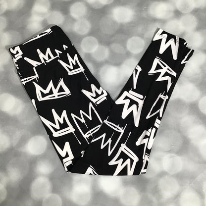 LuLaRoe leggings in Crown Street with black background, white graffiti-style crown pattern, and soft stretchy fabric on a blurred gray background