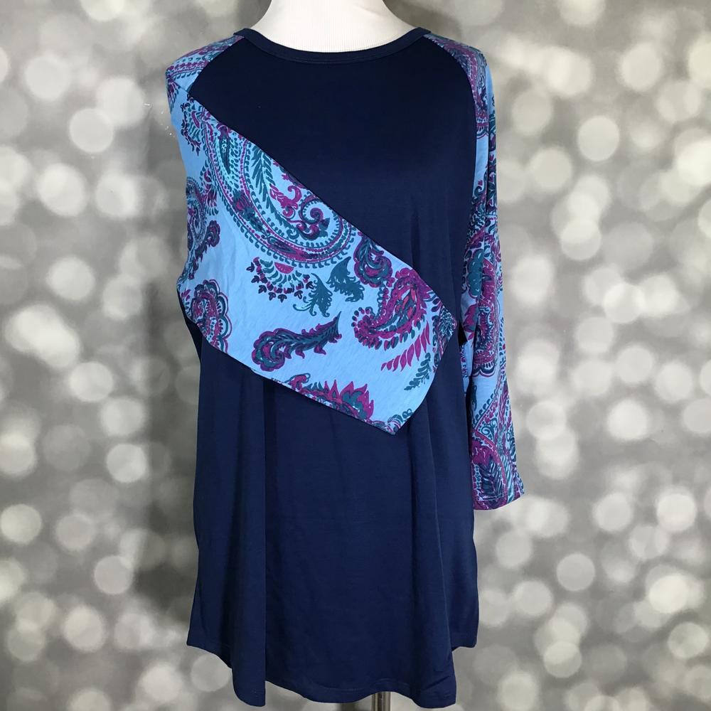 LuLaRoe Randy Tee in Sapphire Orchid Paisley featuring a navy body with aqua raglan sleeves printed in sapphire blue, teal, and orchid purple paisley in size XL.