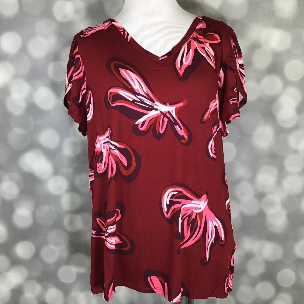 Red dress with pink floral patterns on a mannequin against a blurred background
