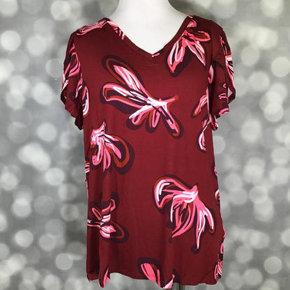 Red dress with pink floral patterns on a mannequin against a blurred background