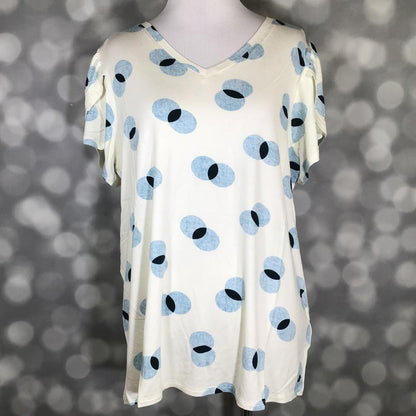 Cream LuLaRoe Remi top with blue and black circular dot print and tulip sleeves, displayed on mannequin against a blurred gray background