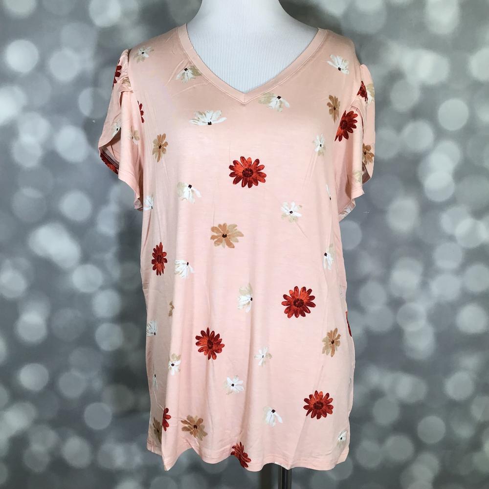 Peach LuLaRoe Remi top with red, white, and tan daisy print and tulip sleeves, displayed on a mannequin against a blurred gray background