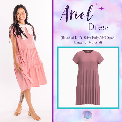 Woman wearing LuLaRoe Ariel Tiered Dress in Solid Blush Petal, a soft blush pink tiered short dress with relaxed fit, feminine silhouette, and comfortable stretch fabric for spring and summer styling.