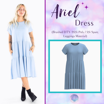 Woman wearing LuLaRoe Ariel Tiered Dress in Solid Powder Blue, a soft pastel blue tiered short dress with relaxed fit, flowy silhouette, and comfortable stretch fabric for spring and summer wear.