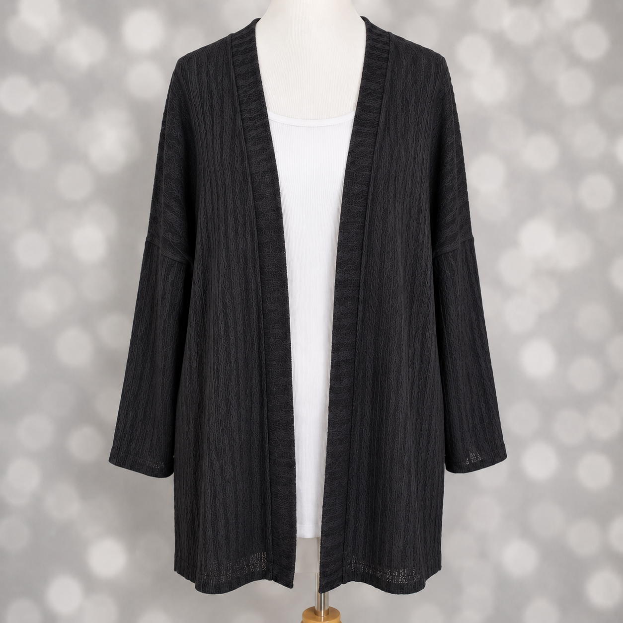 LuLaRoe Connie Lightweight Overlay in Solid Black featuring a lightweight cable knit texture, open front cardigan, relaxed fit, and long sleeves layered over a white ribbed tank.