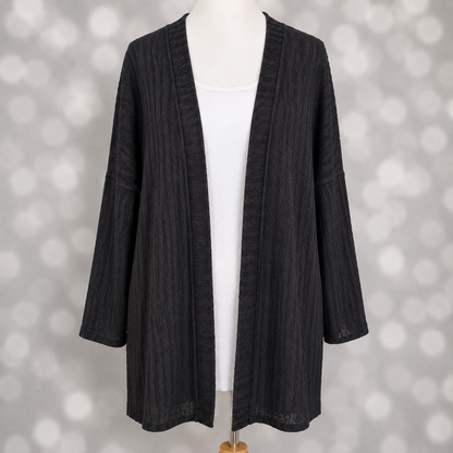 LuLaRoe Connie Lightweight Overlay in Solid Black featuring a lightweight cable knit texture, open front cardigan, relaxed fit, and long sleeves layered over a white ribbed tank.