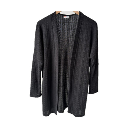 LuLaRoe Connie Lightweight Overlay in Solid Black featuring a lightweight cable knit texture, open front cardigan, relaxed fit, and long sleeves layered over a white ribbed tank.