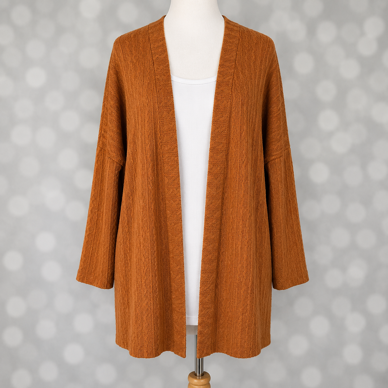 LuLaRoe Connie Lightweight Overlay in Solid Camel featuring a lightweight cable knit texture, open front cardigan, relaxed fit, and long sleeves layered over a white ribbed tank.