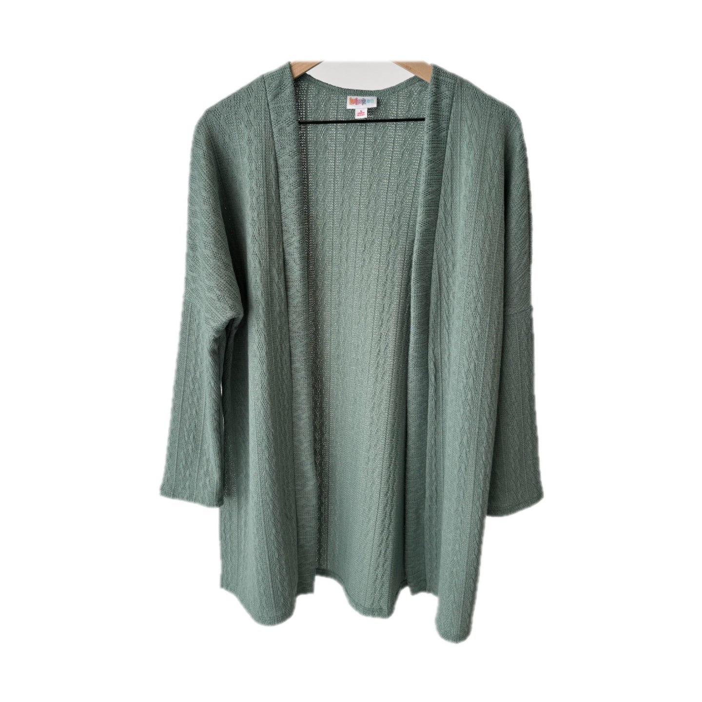 LuLaRoe Connie Lightweight Overlay in Solid Eucalyptus Green featuring a lightweight cable knit texture, open front cardigan, relaxed fit, and long sleeves layered over a white ribbed tank.