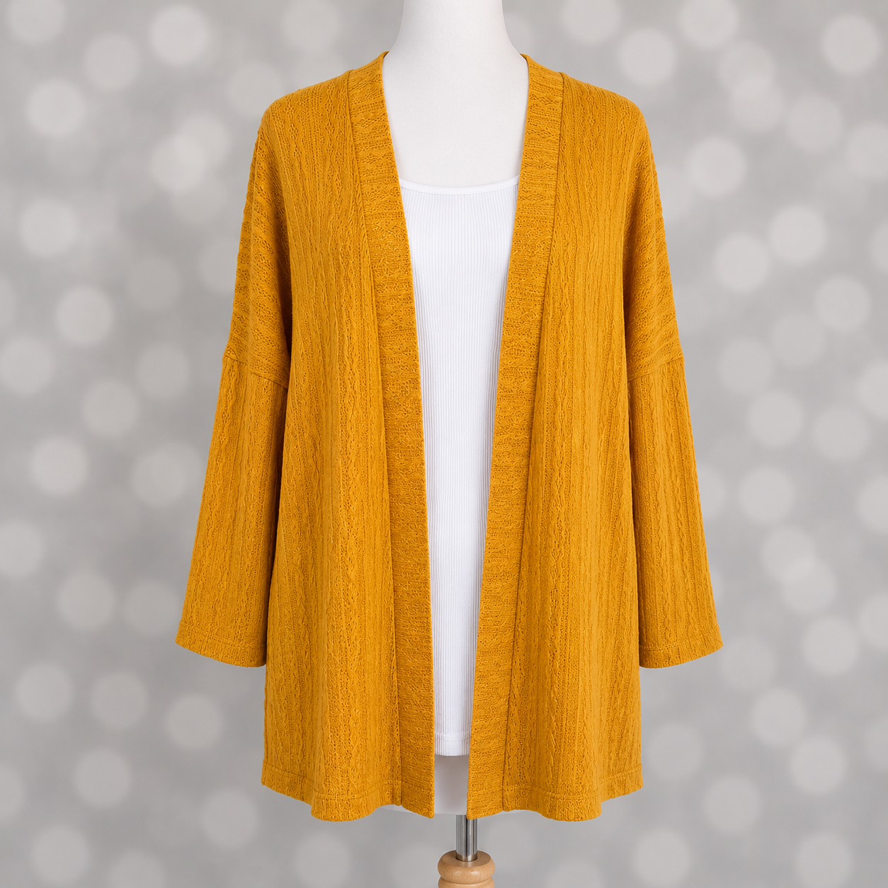 LuLaRoe Connie Lightweight Overlay in Solid Mustard featuring a lightweight cable knit texture, open front cardigan, relaxed fit, and long sleeves layered over a white ribbed tank.
