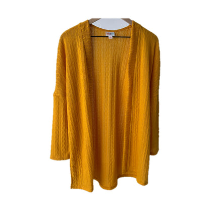 LuLaRoe Connie Lightweight Overlay in Solid Mustard featuring a lightweight cable knit texture, open front cardigan, relaxed fit, and long sleeves layered over a white ribbed tank.