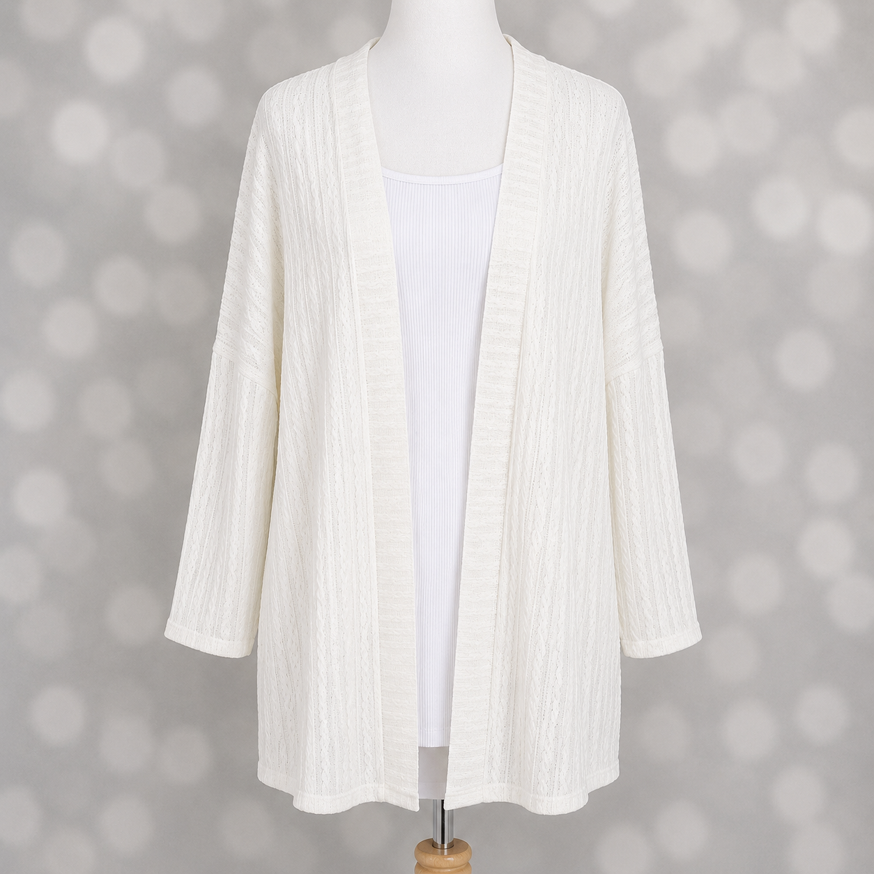 LuLaRoe Connie Lightweight Overlay in Solid White featuring a lightweight cable knit texture, open front cardigan, relaxed fit, and long sleeves layered over a white ribbed tank.