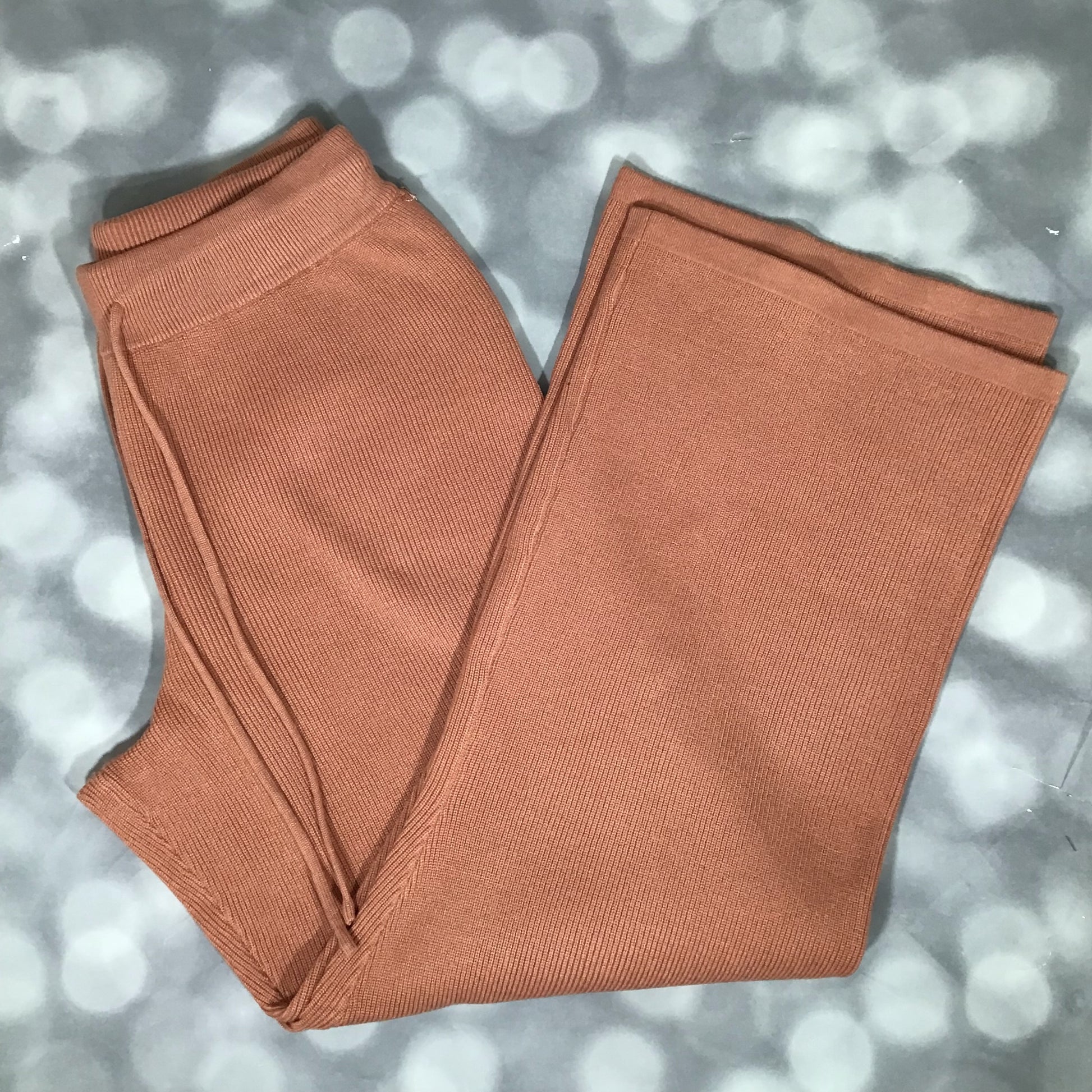 Flat lay of the LuLaRoe Carma Bottom pant in a solid caramel brown color, showing the ribbed waistband with matching drawcord, relaxed full-length leg, and soft micro rib sweater knit texture