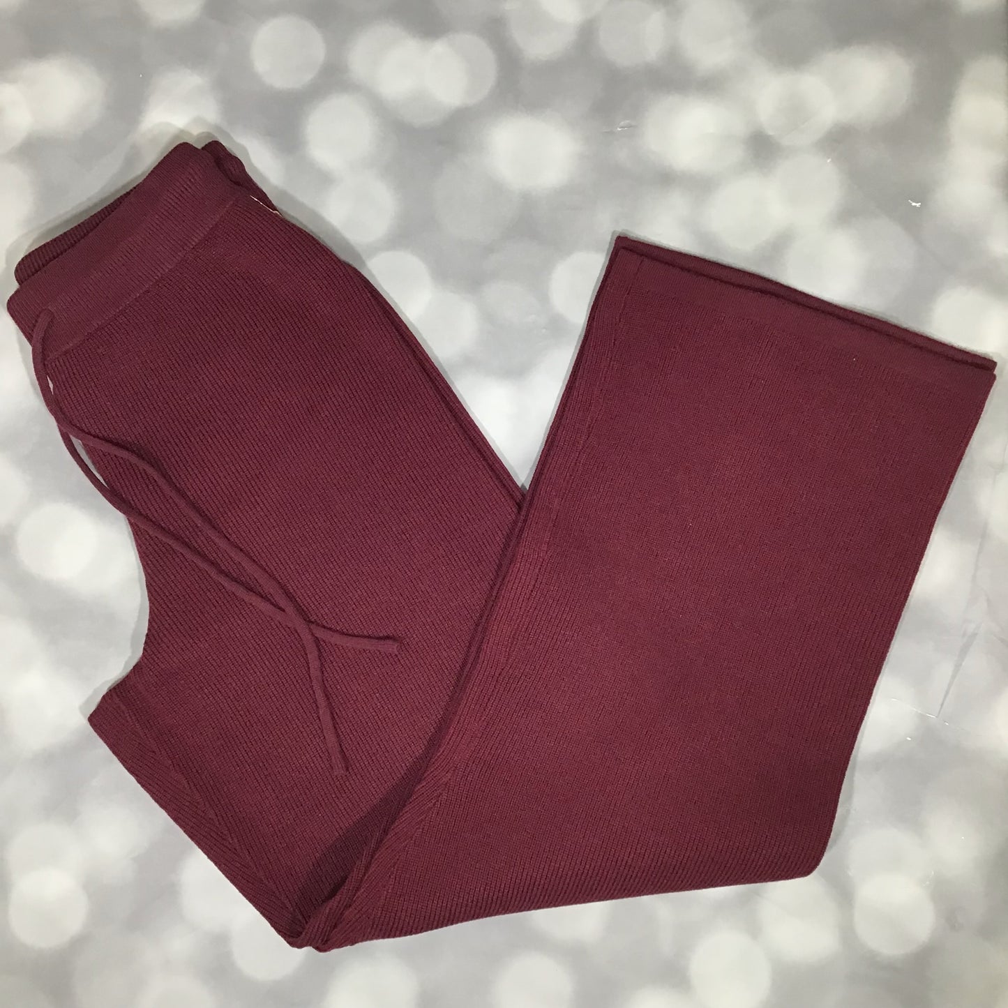 Flat lay of the LuLaRoe Carma Bottom in a solid merlot wine color, showing the ribbed waistband, adjustable drawcord, relaxed full-length leg, and soft micro rib sweater knit fabric