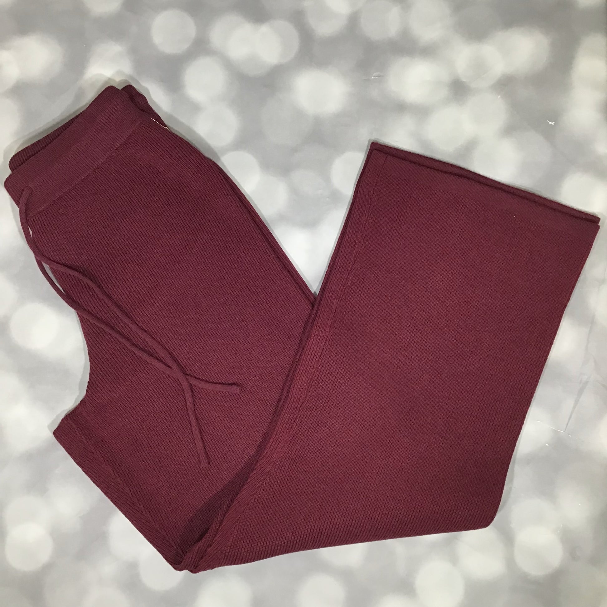 Flat lay of the LuLaRoe Carma Bottom in a solid merlot wine color, showing the ribbed waistband, adjustable drawcord, relaxed full-length leg, and soft micro rib sweater knit fabric