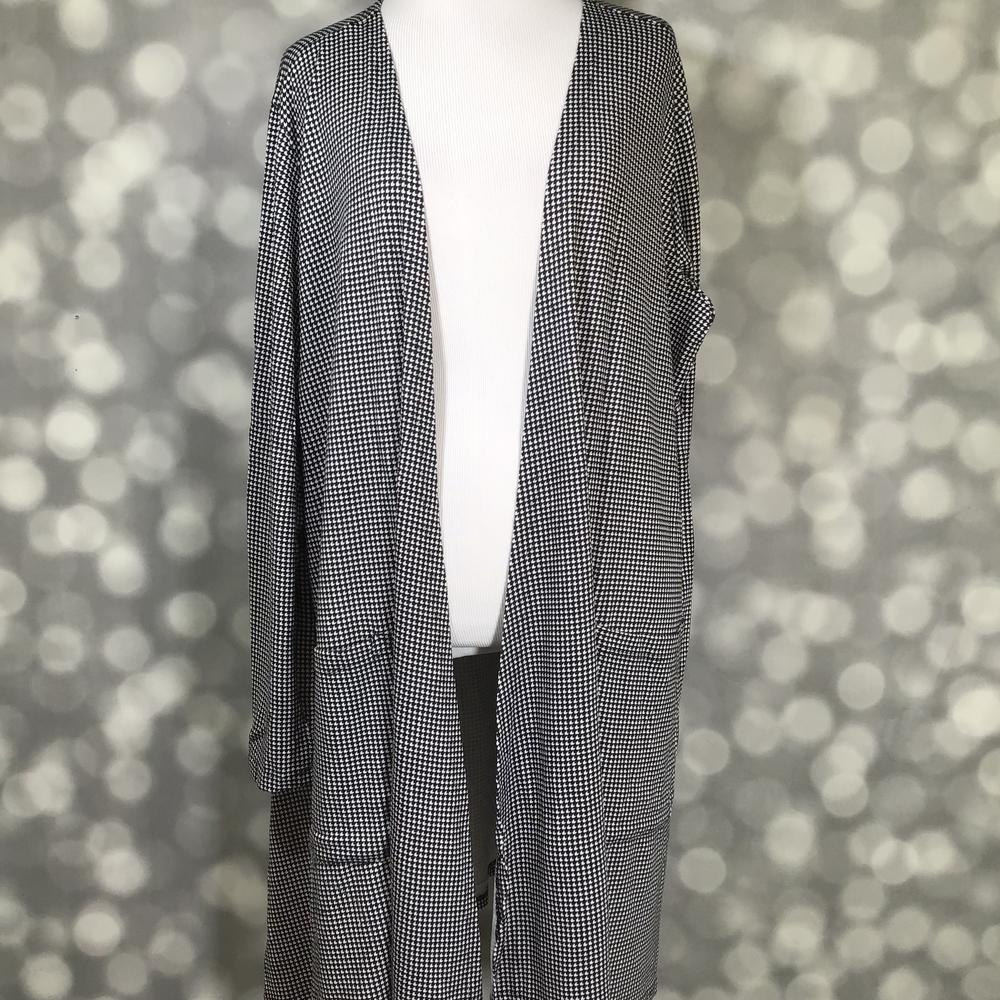 Front view of LuLaRoe Caroline Cardigan on mannequin featuring black and white houndstooth print, open front, and cropped sleeve length against a blurred background