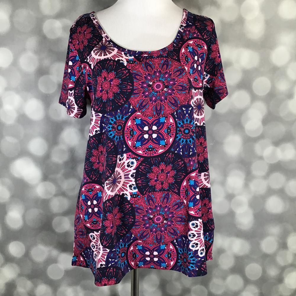 Front view of LuLaRoe Classic T on mannequin in vibrant magenta and blue mandala pattern with short sleeves and a relaxed curved hemline