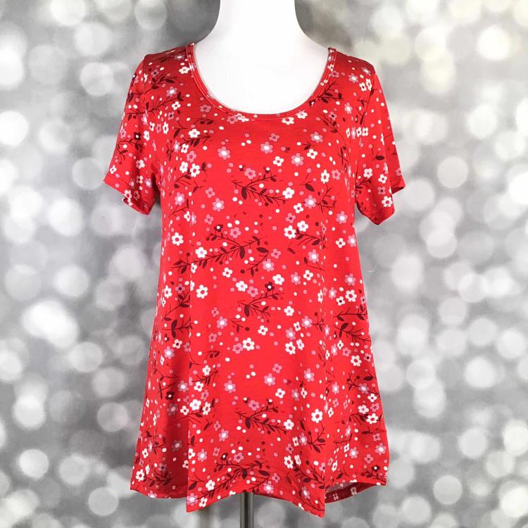 Front view of LuLaRoe Classic T displayed on mannequin in bright red fabric with pink and white ditsy floral print and flattering curved hem