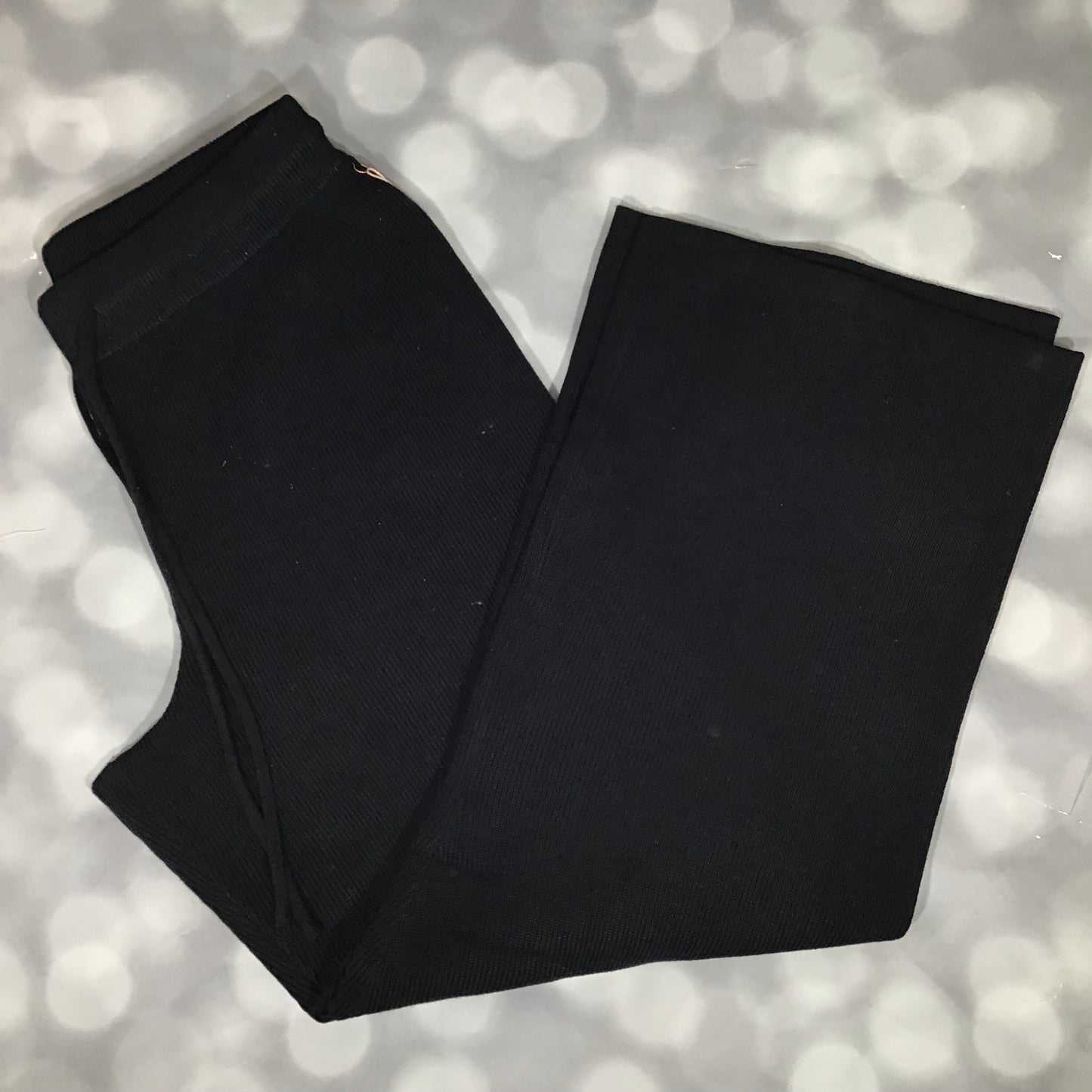 Flat lay of the LuLaRoe Carma Bottom in solid black, featuring a ribbed waistband with drawstring, relaxed full-length legs, and soft micro rib sweater knit fabric