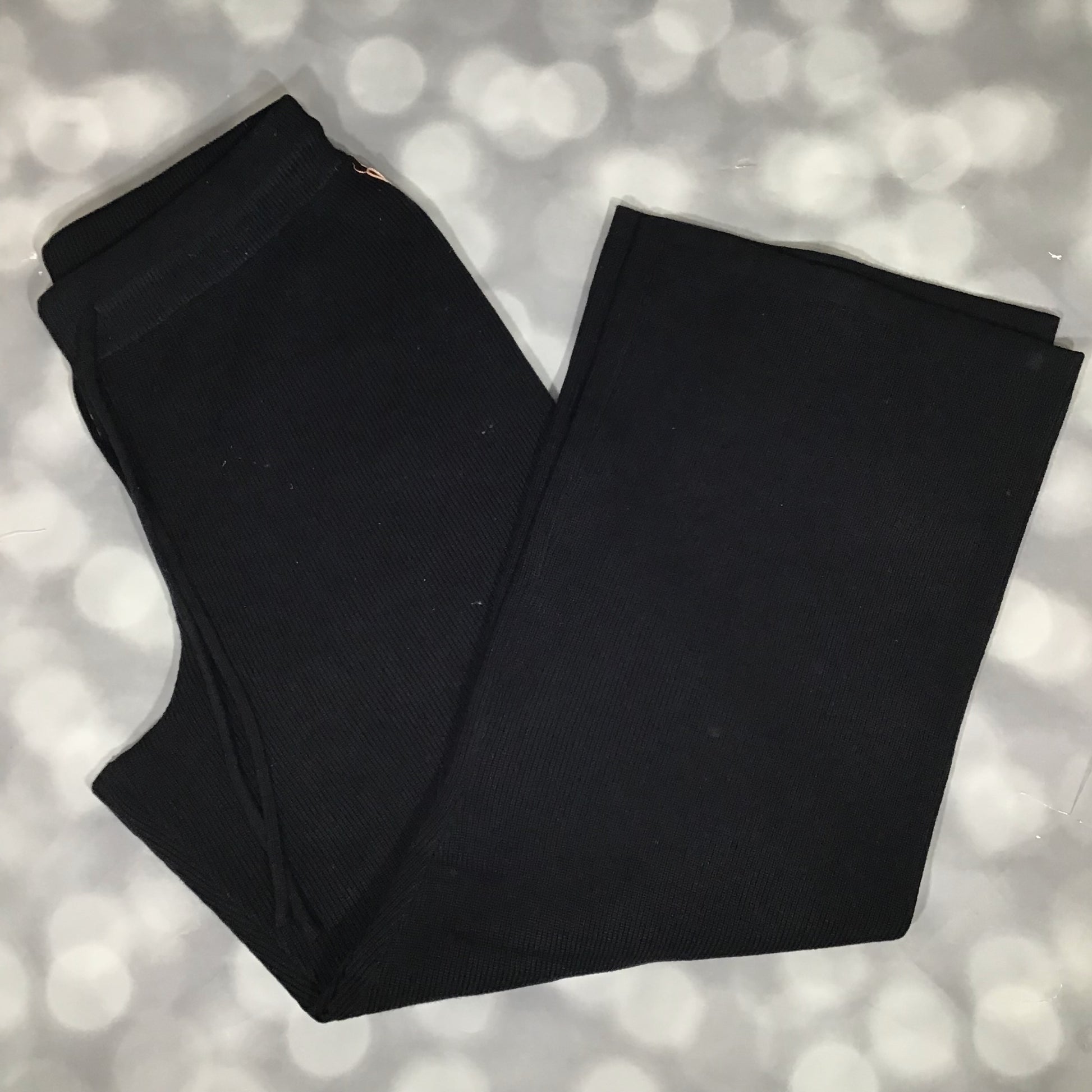 Flat lay of the LuLaRoe Carma Bottom in solid black, featuring a ribbed waistband with drawstring, relaxed full-length legs, and soft micro rib sweater knit fabric