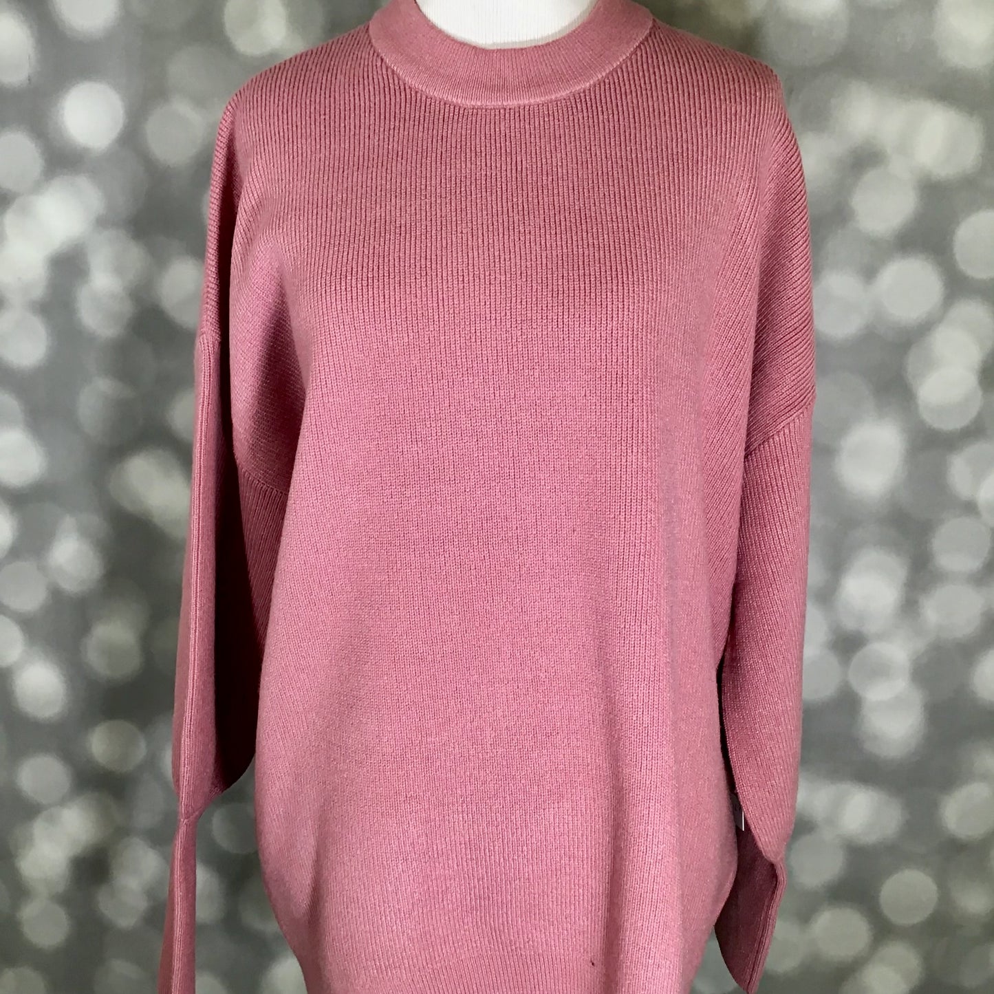 Pink sweater on a mannequin against a blurred background